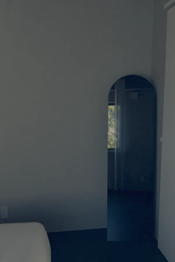 薄暗い部屋の角に立てたアーチ形の姿見。鏡の中に隣の部屋の窓と外の緑が映る